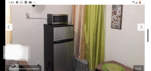 a kitchen with a refrigerator, stove, and microwave at Studio and 1 Bedroom Apartments - Bronx in Bronx