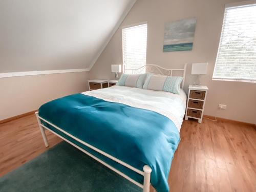 a bedroom with a bed with a blue blanket at Whitesands in Dunsborough
