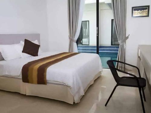 ein Hotelzimmer mit einem Bett und einem Stuhl in der Unterkunft Bangka Suite Mitra RedDoorz in Jakarta