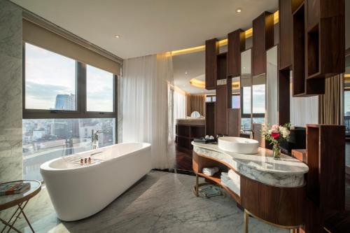 a bathroom with a tub and a large window at Soleil Boutique Hotel Hanoi in Hanoi