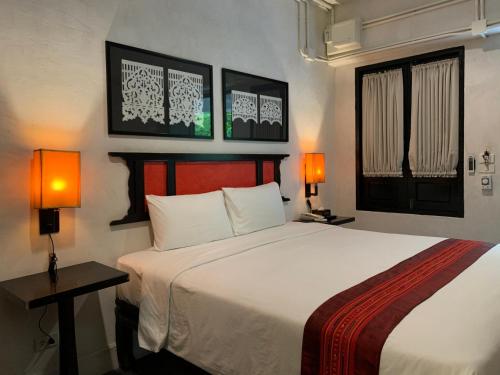 a bedroom with a large bed with two lamps on it at 99 The Gallery Hotel- SHA Extra Plus in Chiang Mai