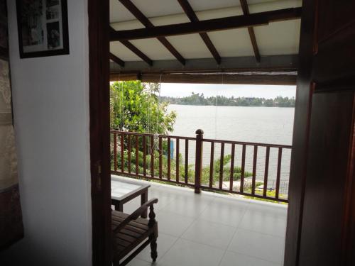 a room with a balcony with a view of the water at Sapara River Guest in Bentota