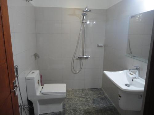 a bathroom with a toilet and a sink and a shower at Sapara River Guest in Bentota