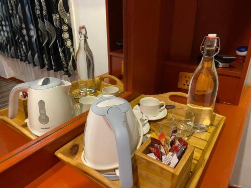 Niu Inn & Spa في هولهومالي: طاولة مع غلاية الشاي وزجاجة من النبيذ