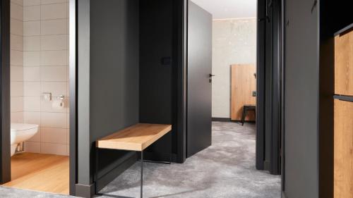 baño con paredes negras y banco de madera en OREA Congress Hotel Brno, en Brno
