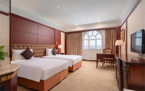 a hotel room with two beds and a television at Wyndham Shanghai Hongqiao-Near NECC in Shanghai