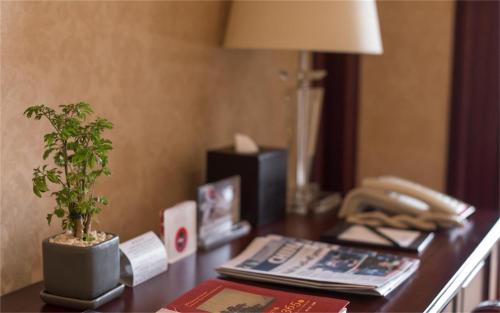 a desk with a phone and a potted plant on it at Wyndham Shanghai Hongqiao-Near NECC in Shanghai