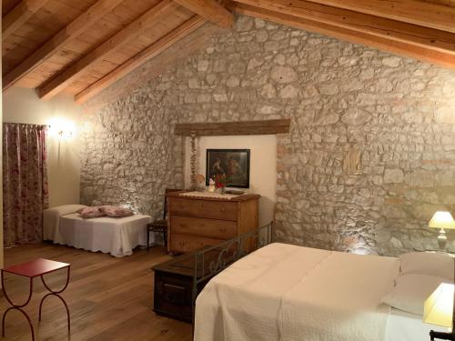 San Vito al TorreにあるBorgo Palazzo Steffaneoの石壁のベッドルーム1室(ベッド2台付)