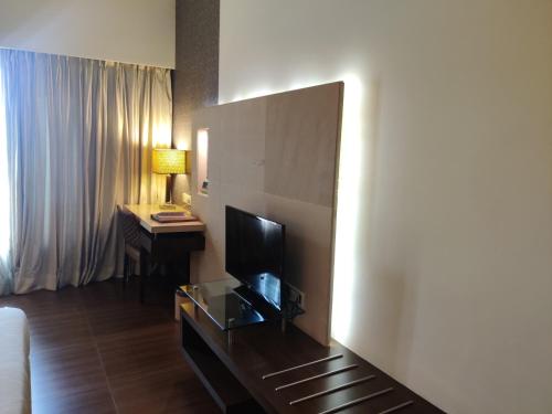 a hotel room with a television and a desk at Hotel Satkar Residency in Thane