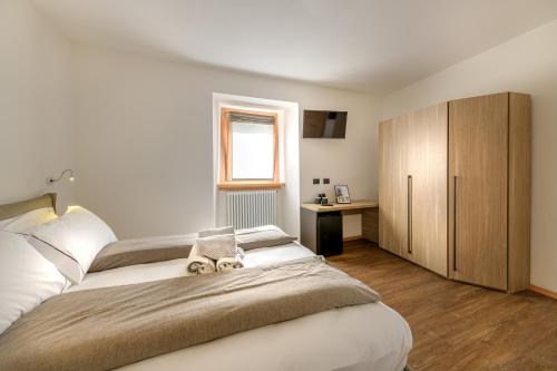 a bedroom with a large bed and a desk at Agriturismo Cà Gianin in Vervio
