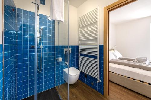 a blue tiled bathroom with a toilet and a bed at Agriturismo Cà Gianin in Vervio
