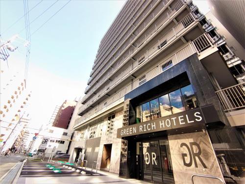 a tall building with a green rush hotels sign on it at Green Rich Hotel Kobe Sannomiya (Artificial hot spring Futamata Yunohana) in Kobe