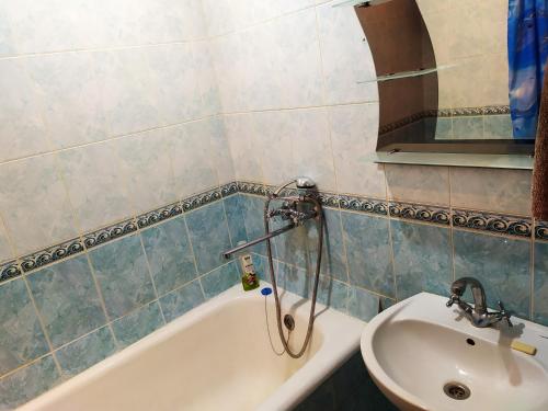 uma casa de banho com uma banheira e um lavatório em Ильинская 3к посуточно почасово em Sumy