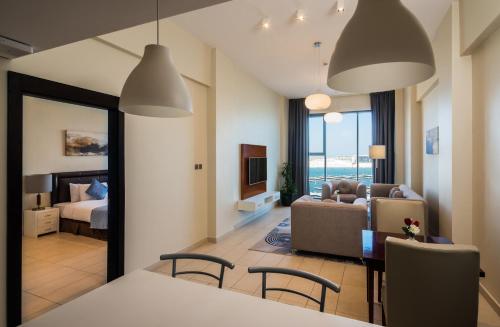 a living room with a couch and a bedroom at Boudl Al Jubail in Al Jubail