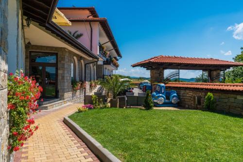 a house with a yard with a blue car in it at Complex Panorama in Elena