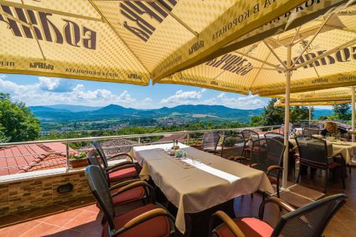 a restaurant with tables and chairs with mountains in the background at Complex Panorama in Elena