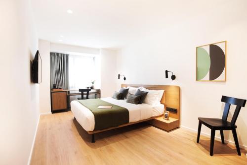 a bedroom with a bed and a desk and a chair at Noa Hotel in Thessaloniki