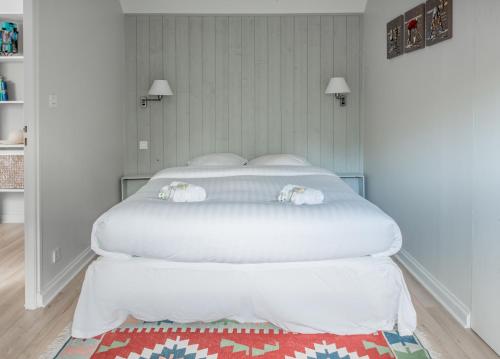 Una cama blanca en un dormitorio blanco con una alfombra roja en LE DUPLEX - Appartement familial cosy, en Saint-Nazaire