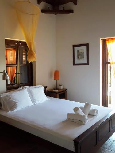 a bedroom with a large white bed with towels on it at Rathimata Villas in Stoupa