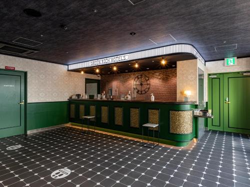 a restaurant with green doors and a counter with stools at Green Rich Hotel Kobe Sannomiya (Artificial hot spring Futamata Yunohana) in Kobe