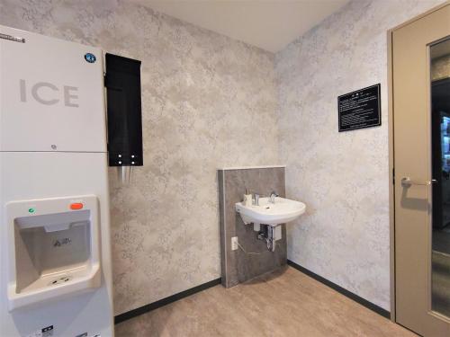 a bathroom with a sink and a urinal at Green Rich Hotel Kobe Sannomiya (Artificial hot spring Futamata Yunohana) in Kobe