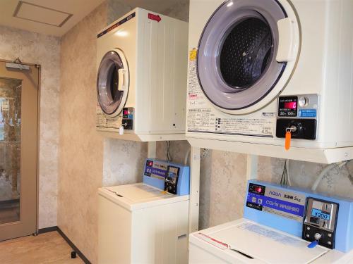 a laundry room with a washing machine and a washer at Green Rich Hotel Kobe Sannomiya (Artificial hot spring Futamata Yunohana) in Kobe