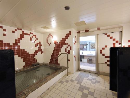 a large bathroom with a tub in the middle at Green Rich Hotel Kobe Sannomiya (Artificial hot spring Futamata Yunohana) in Kobe