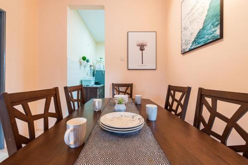 a dining room with a wooden table and chairs at 3BR Retreat Homestay near to GoldCoast, Sepang by Verano in Sungai Pelik