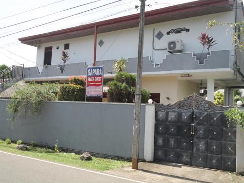 a sign in front of a house with a gate at Sapara River Guest in Bentota