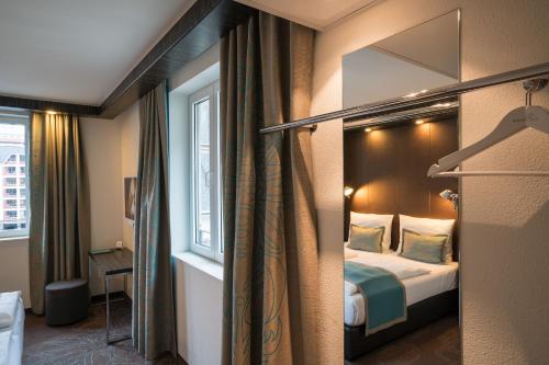 Habitación de hotel con cama y ventana en Motel One Leipzig-Nikolaikirche en Leipzig