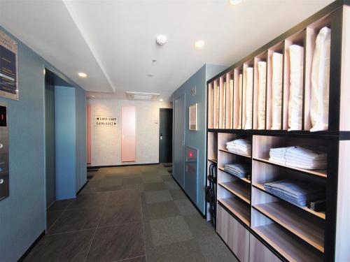 a walk in closet with blue walls and wooden shelves at Green Rich Hotel Kobe Sannomiya (Artificial hot spring Futamata Yunohana) in Kobe