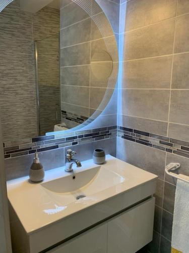 une salle de bain avec un lavabo et un miroir dans l'établissement Chez Mado, à Deauville