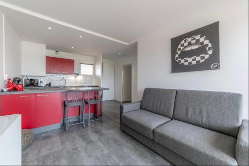 a living room with a couch and a kitchen at Appartement à Arcachon à 3 min à pied de la plage in Arcachon
