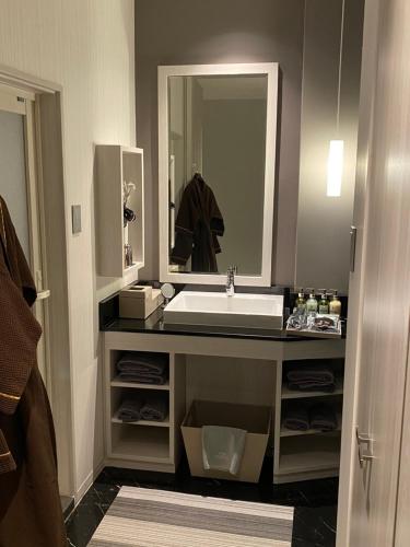 a bathroom with a sink and a mirror at ホテル ポルト 男塾ホテルグループ in Himeji