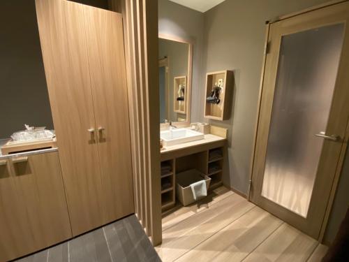 a bathroom with a sink and a mirror at ホテル ポルト 男塾ホテルグループ in Himeji