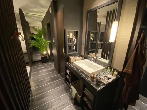 a bathroom with a sink and a large mirror at ホテル ポルト 男塾ホテルグループ in Himeji
