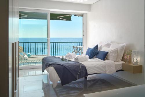 a bedroom with a bed with a view of the ocean at Sunlight Properties - Sky blue - 3 bedroom flat with sea view on the Promenade des Anglais in Nice