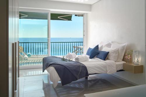 une chambre avec un lit avec vue sur l'océan dans l'établissement Sunlight Properties - Sky blue - 3 bedroom flat with sea view on the Promenade des Anglais, à Nice