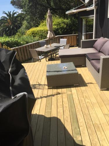 a wooden deck with a couch and a table at Palm Heights in Palm Beach