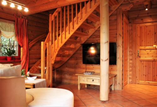 ein Wohnzimmer mit einer Treppe in einem Holzhaus in der Unterkunft Chalet mit Schlossblick Wernigerode, Chalet 2 in Wernigerode