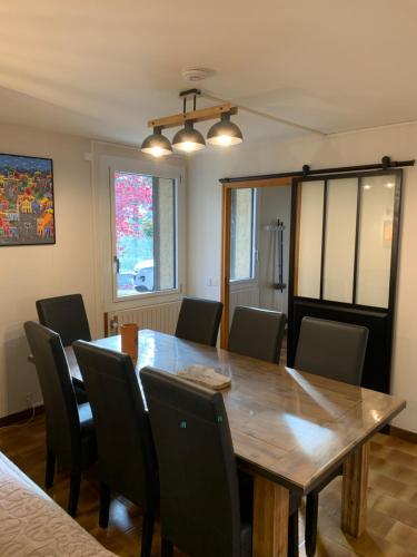 a dining room with a wooden table and chairs at maison blanche in Briançon