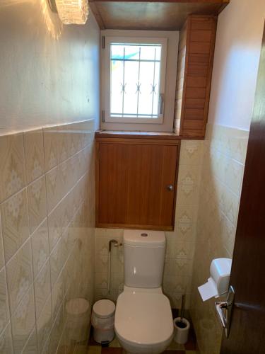 a small bathroom with a toilet and a window at maison blanche in Briançon