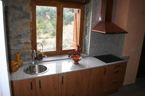um balcão de cozinha com um lavatório e uma janela em Casa Rural Urbe em Campodarbe