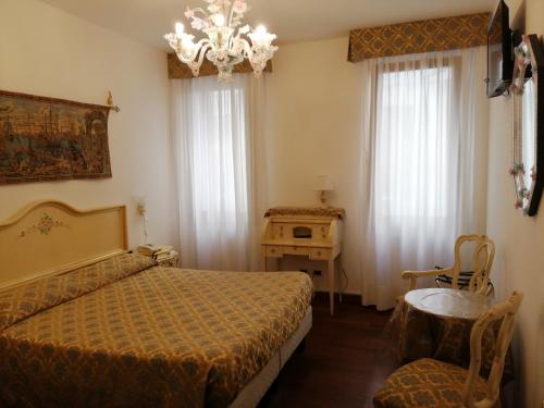 a bedroom with a bed and a chandelier at Hotel Orion in Venice