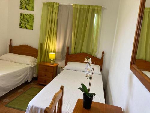 a bedroom with two beds and a table with a lamp at Pensi&oacute;n Amparo Las Hayas in Valle Gran Rey
