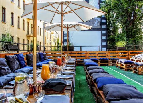 a row of tables with chairs and an umbrella at Stare Kino Cinema Residence in Łódź