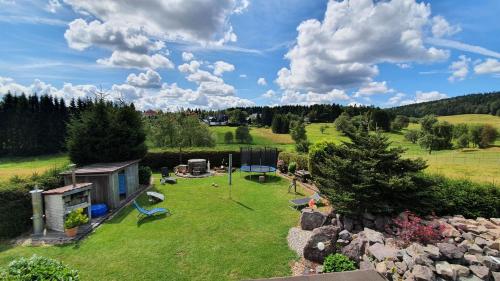 een luchtzicht op een tuin met een speeltuin bij Monis gemütliche Ferienwohnungen in Schmiedefeld am Rennsteig