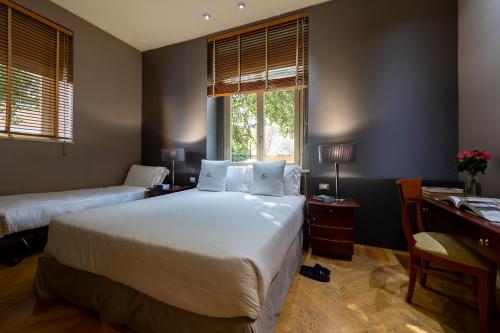 a bedroom with two beds and a desk and a window at Hotel Principe Torlonia in Rome