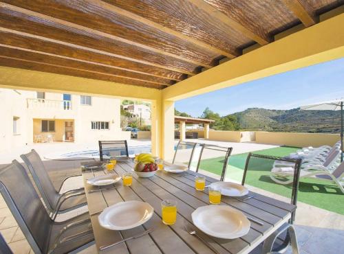 une table en bois avec des assiettes de nourriture sur une terrasse dans l'établissement Villa Mercedes - Plusholidays, à Calp