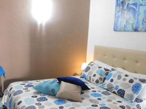 a bed with blue and white pillows on it at Case Vacanza Elisir in Favignana